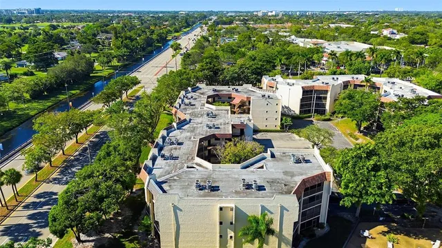 an aerial view of residential houses with outdoor space and trees