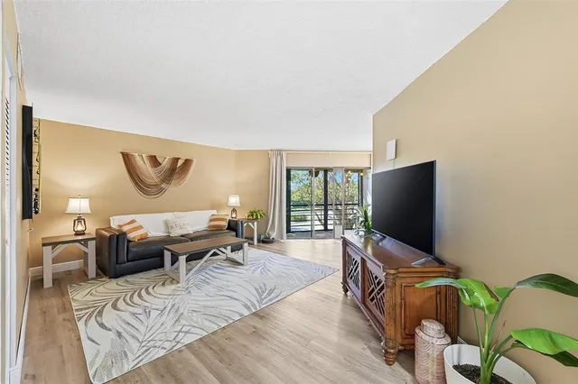 a living room with furniture a flat screen tv and a floor to ceiling window