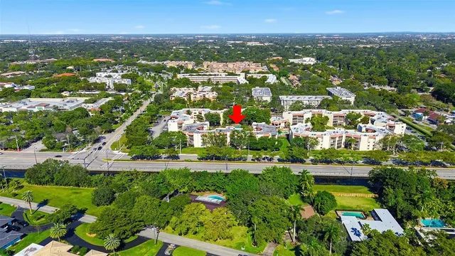 an aerial view of residential houses with outdoor space and trees