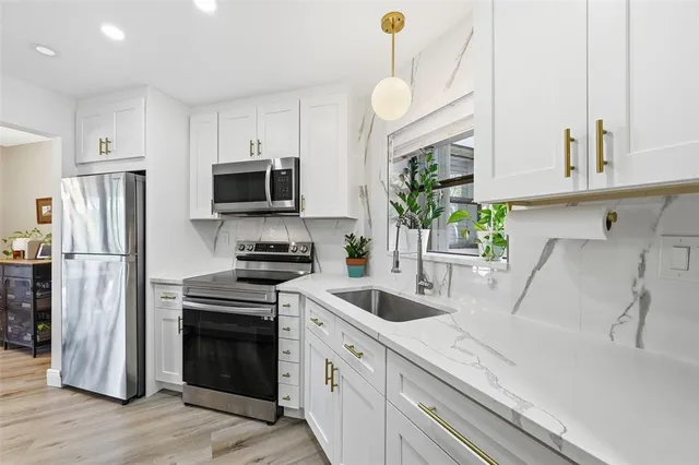 a kitchen with a sink a microwave a refrigerator and cabinets
