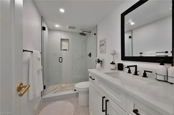 a bathroom with a sink a toilet and shower