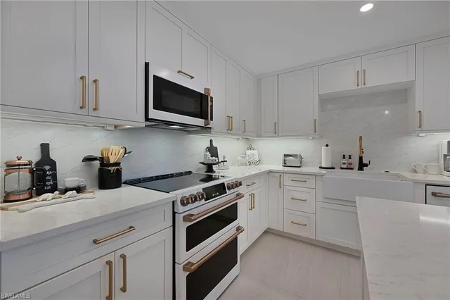 a kitchen with white cabinets and stainless steel appliances