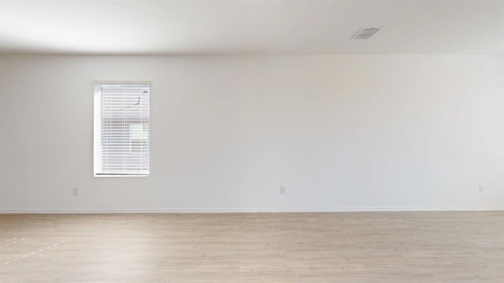 9757 Platteview Road Fort Worth, TX 76179 - Photo 5 of 19 Room featuring light wood-finish flooring, white walls, and a single window with horizontal blinds