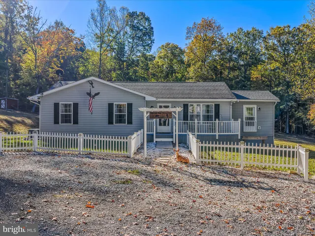 a view of a house with a small yard and a large tree
