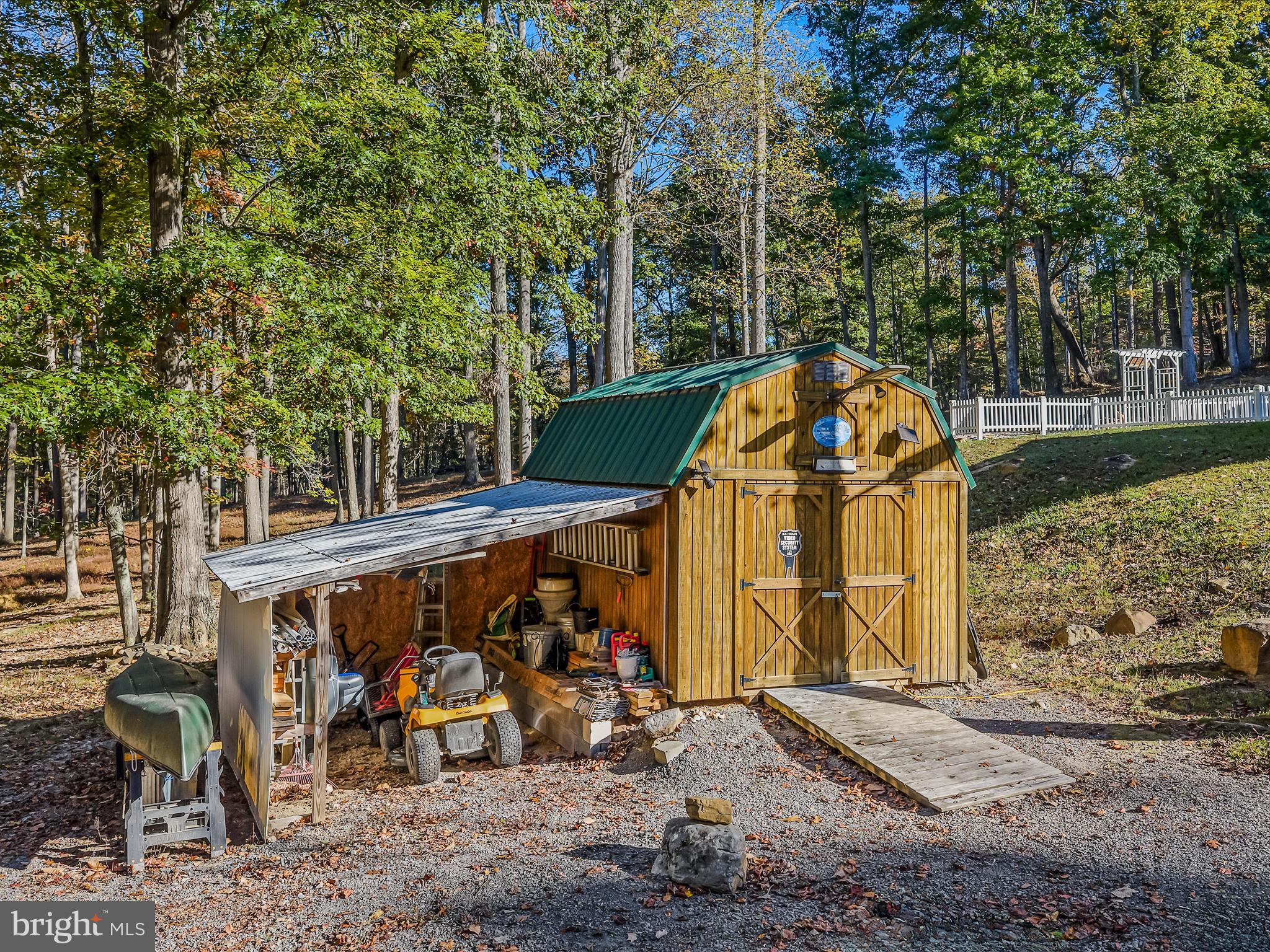 154 Brooklyn's Way Great Cacapon, WV 25422 - Photo 40 of 64 a view of a wooden house with large trees and playing area