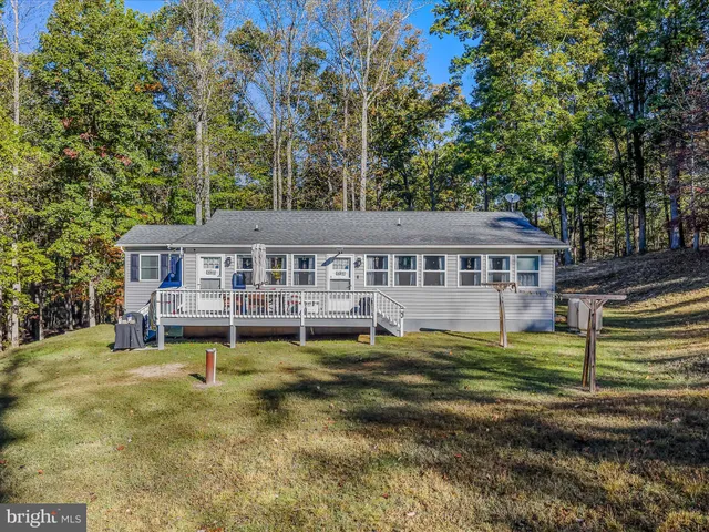 a view of a house with a small yard and wooden floor and fence