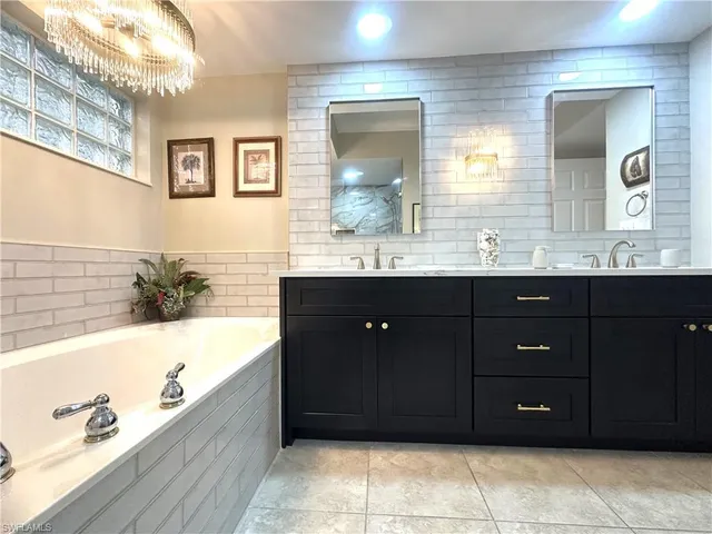 a bathroom with a tub a sink and mirror