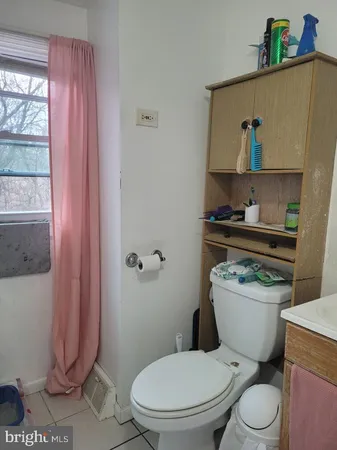 a white toilet sitting next to a bathroom sink and a shower