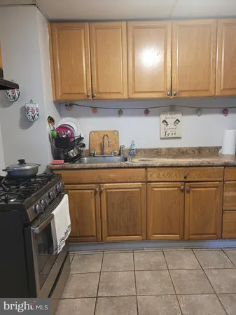 a kitchen with granite countertop a stove top oven sink and cabinets