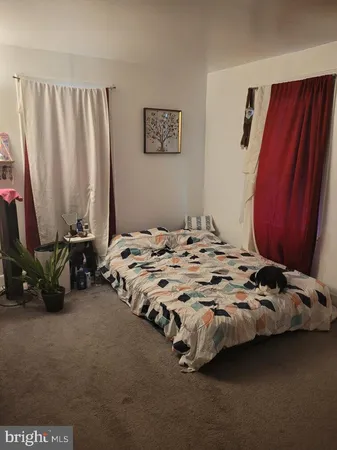 a bedroom with a bed a dresser and a window