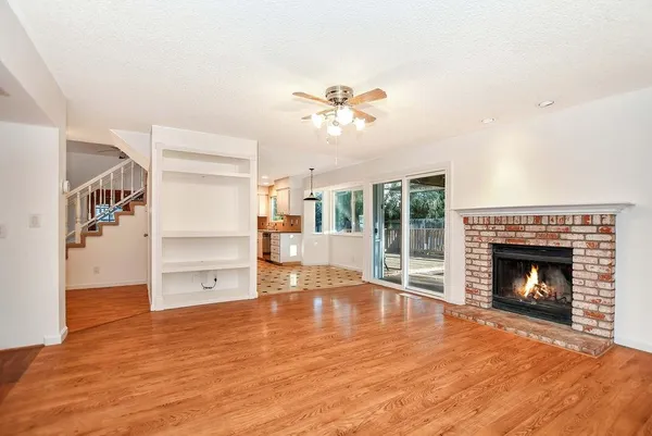 a view of empty room with wooden floor and fireplace