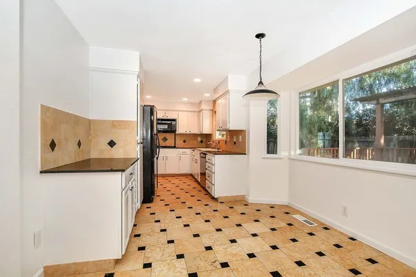 a kitchen with granite countertop a refrigerator a stove a sink dishwasher and wooden floor