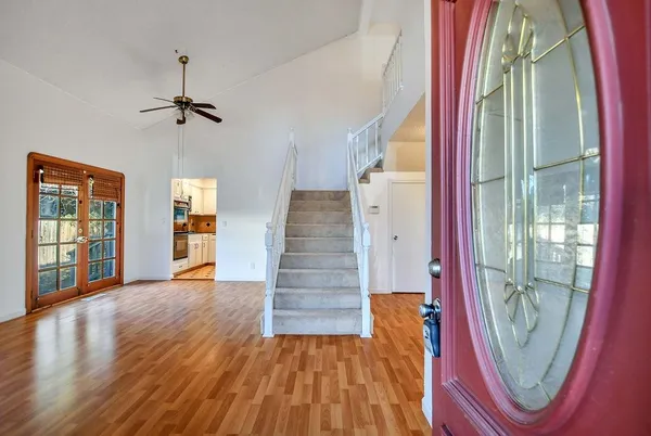 a view of empty room with wooden floor and fan