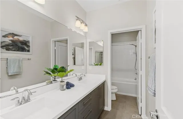 a bathroom with a sink vanity mirror and toilet