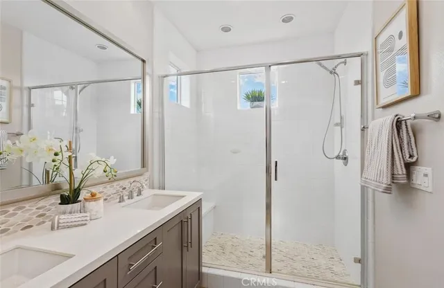 a bathroom with a granite countertop shower sink vanity and mirror