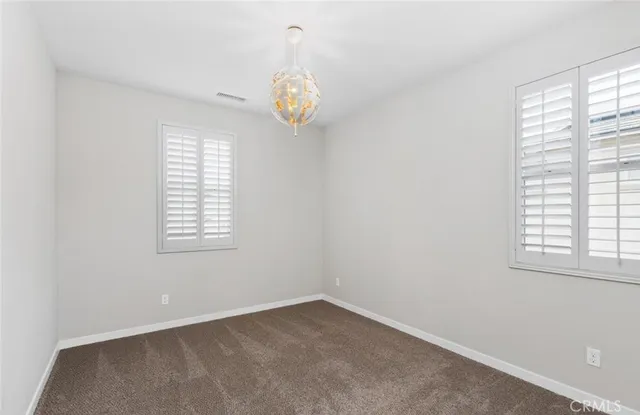 an empty room with windows and wooden floor