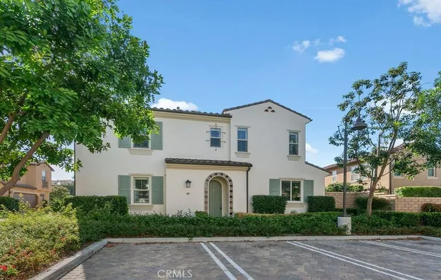 a view of a white house with a yard and plants