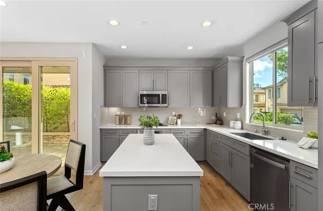a kitchen that has a sink a table and chairs in it