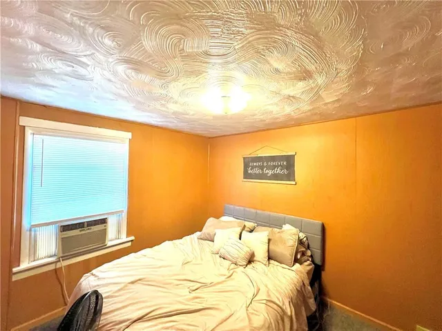 a bed sitting in a bedroom next to a window