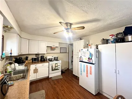 a kitchen with a refrigerator a stove top oven a sink and cabinets