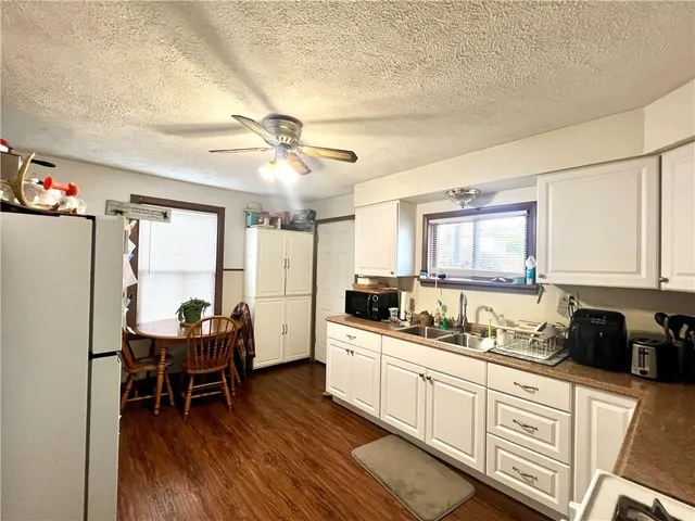 a kitchen with table chairs cabinets and wooden floor