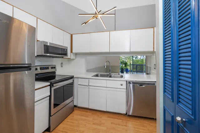 a kitchen with stainless steel appliances a sink cabinets and a window