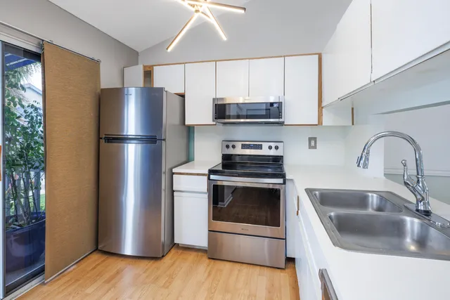 a kitchen with a refrigerator sink and wooden cabinets