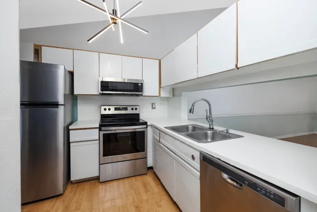 a kitchen with stainless steel appliances a sink a stove a microwave and cabinets