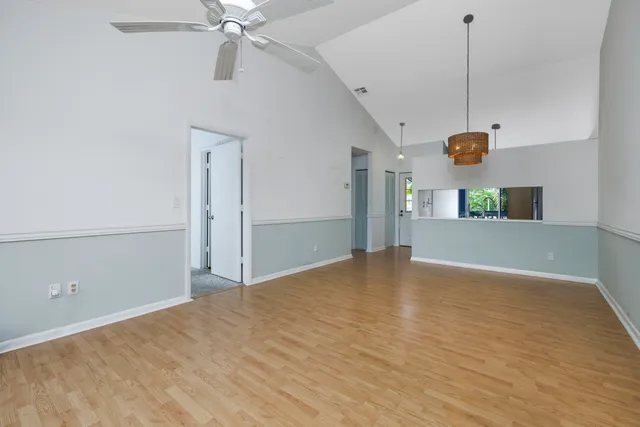 a view of a room with a ceiling fan and hardwood floor