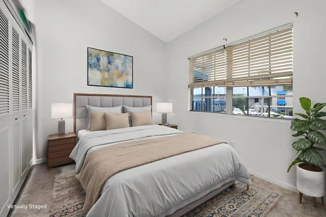 a bedroom with a large bed and a potted plant