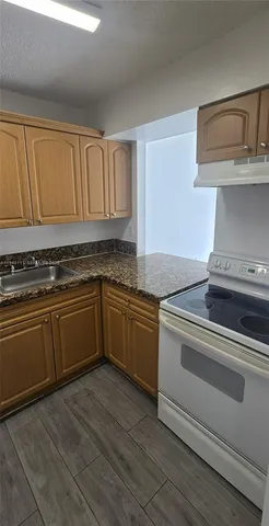 a kitchen with granite countertop a stove and a sink
