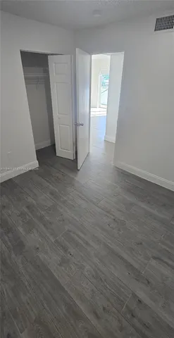 a view of empty room with window and hardwood floor