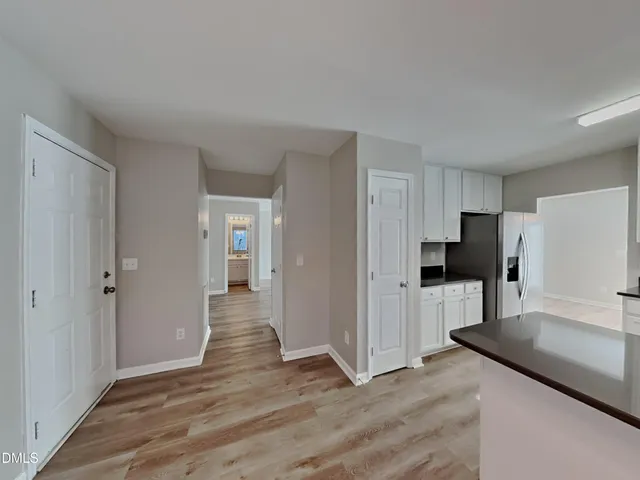a view of a kitchen with wooden floor and a refrigerator