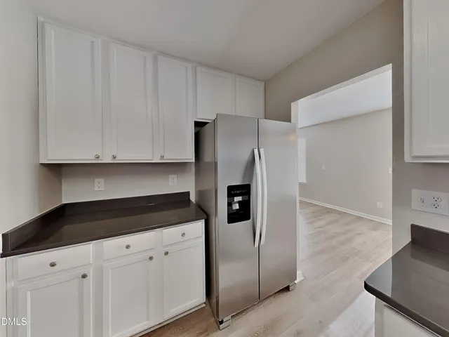 a kitchen with stainless steel appliances white cabinets and a refrigerator