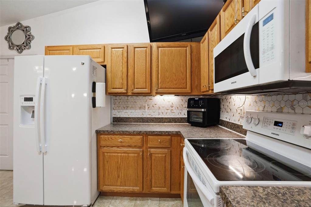 15396 Fleetwood Road Weeki Wachee, FL 34614 - Photo 11 of 66 a kitchen with stainless steel appliances granite countertop a sink a stove and a refrigerator with wooden floor