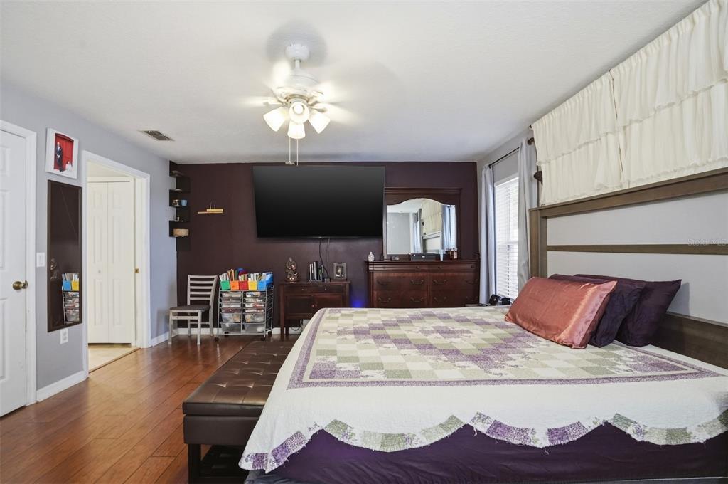 15396 Fleetwood Road Weeki Wachee, FL 34614 - Photo 26 of 66 a bedroom with a large bed and a chandelier