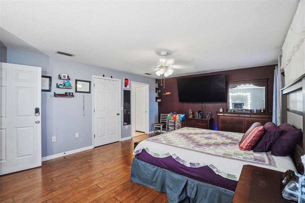 15396 Fleetwood Road Weeki Wachee, FL 34614 - Photo 27 of 66 a spacious bedroom with a bed and a flat screen tv