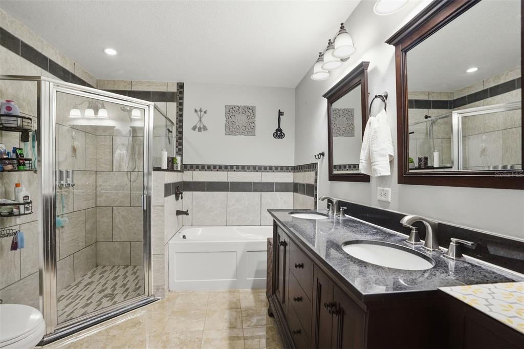15396 Fleetwood Road Weeki Wachee, FL 34614 - Photo 30 of 66 a bathroom with a granite countertop sink mirror and shower