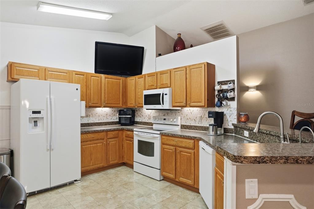 15396 Fleetwood Road Weeki Wachee, FL 34614 - Photo 8 of 66 a kitchen with stainless steel appliances granite countertop a sink stove and refrigerator