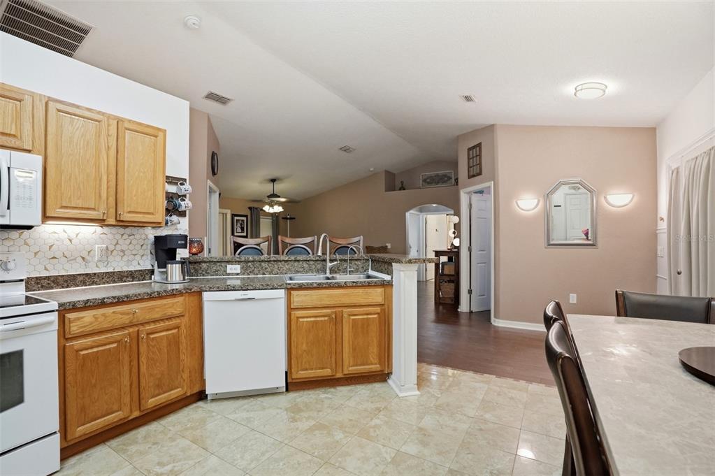 15396 Fleetwood Road Weeki Wachee, FL 34614 - Photo 10 of 66 a kitchen with kitchen island granite countertop a sink counter top space and cabinets
