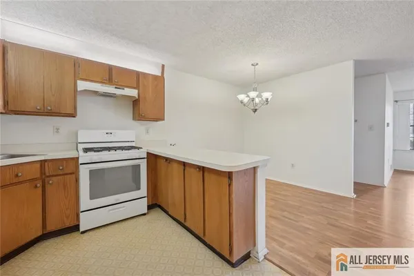 a kitchen with a stove cabinets and wooden floor