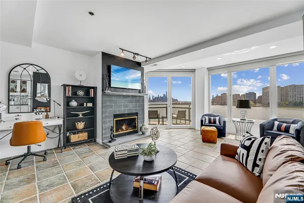 a living room with furniture a fireplace and a large window