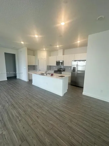 a large kitchen with stainless steel appliances granite countertop a stove a sink and a refrigerator