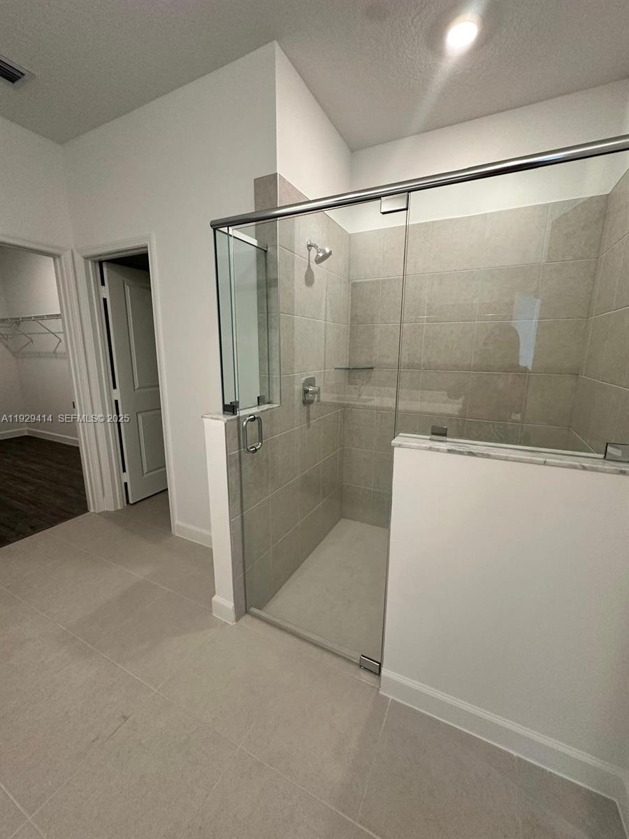 1443 Tangled Orchard Trace, Unit 1443 Loxahatchee, FL 33470 - Photo 13 of 33 a bathroom with a glass shower door