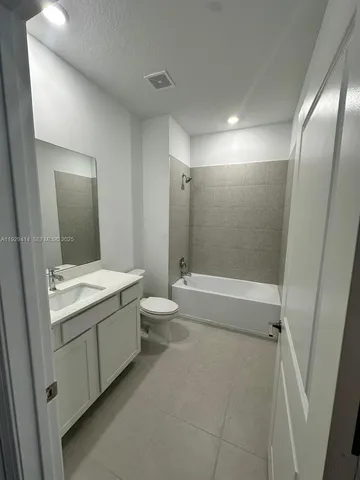 a bathroom with a granite countertop sink mirror vanity and toilet