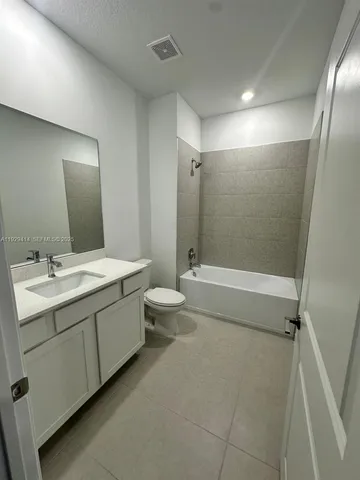 a bathroom with a double vanity sink toilet mirror and bathtub