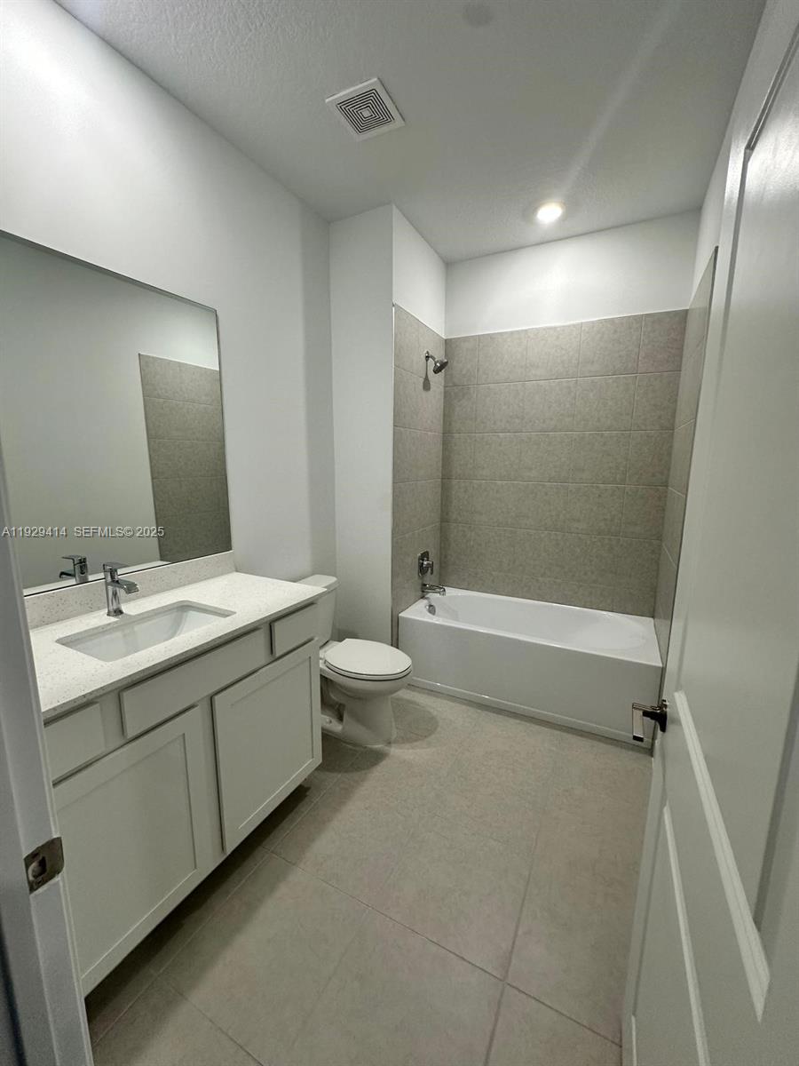1443 Tangled Orchard Trace, Unit 1443 Loxahatchee, FL 33470 - Photo 21 of 33 a bathroom with a double vanity sink toilet mirror and bathtub