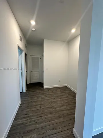 a view of hallway with wooden floor