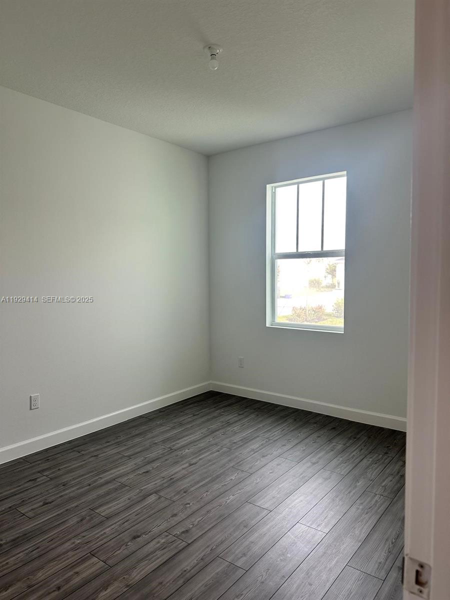 1443 Tangled Orchard Trace, Unit 1443 Loxahatchee, FL 33470 - Photo 26 of 33 an empty room with wooden floor and windows