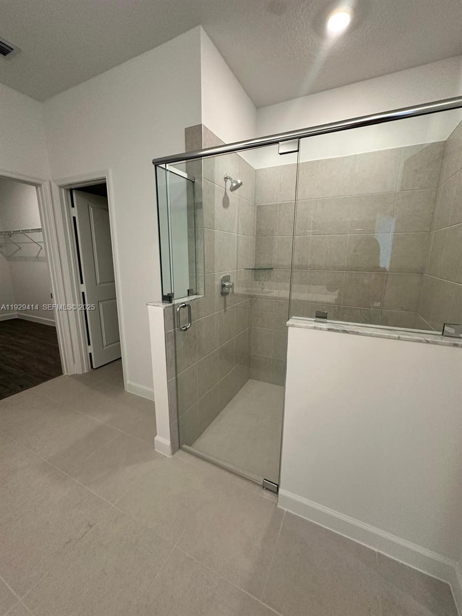 1443 Tangled Orchard Trace, Unit 1443 Loxahatchee, FL 33470 - Photo 29 of 33 a bathroom with a glass shower door